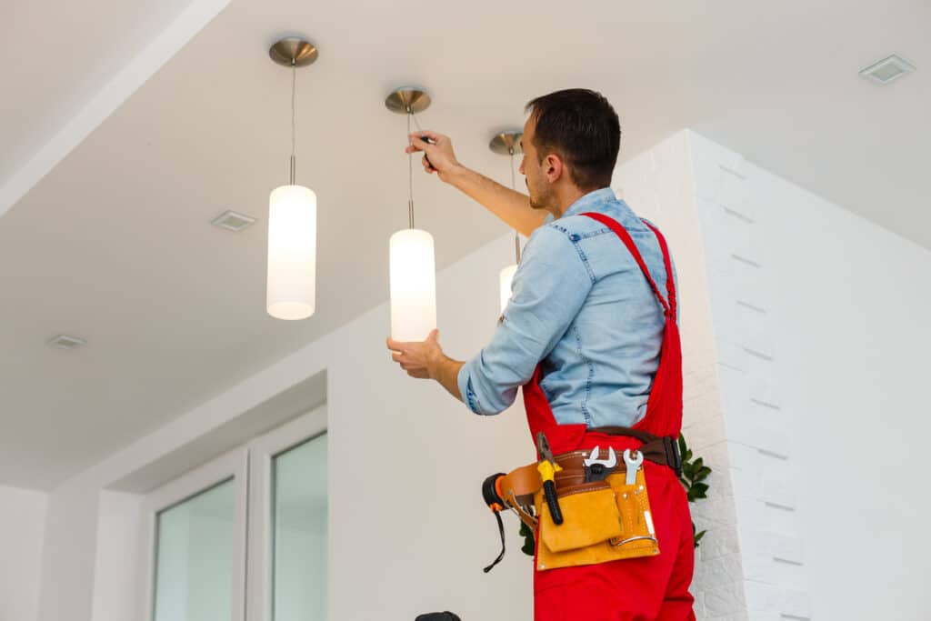 worker installing ceiling lamp